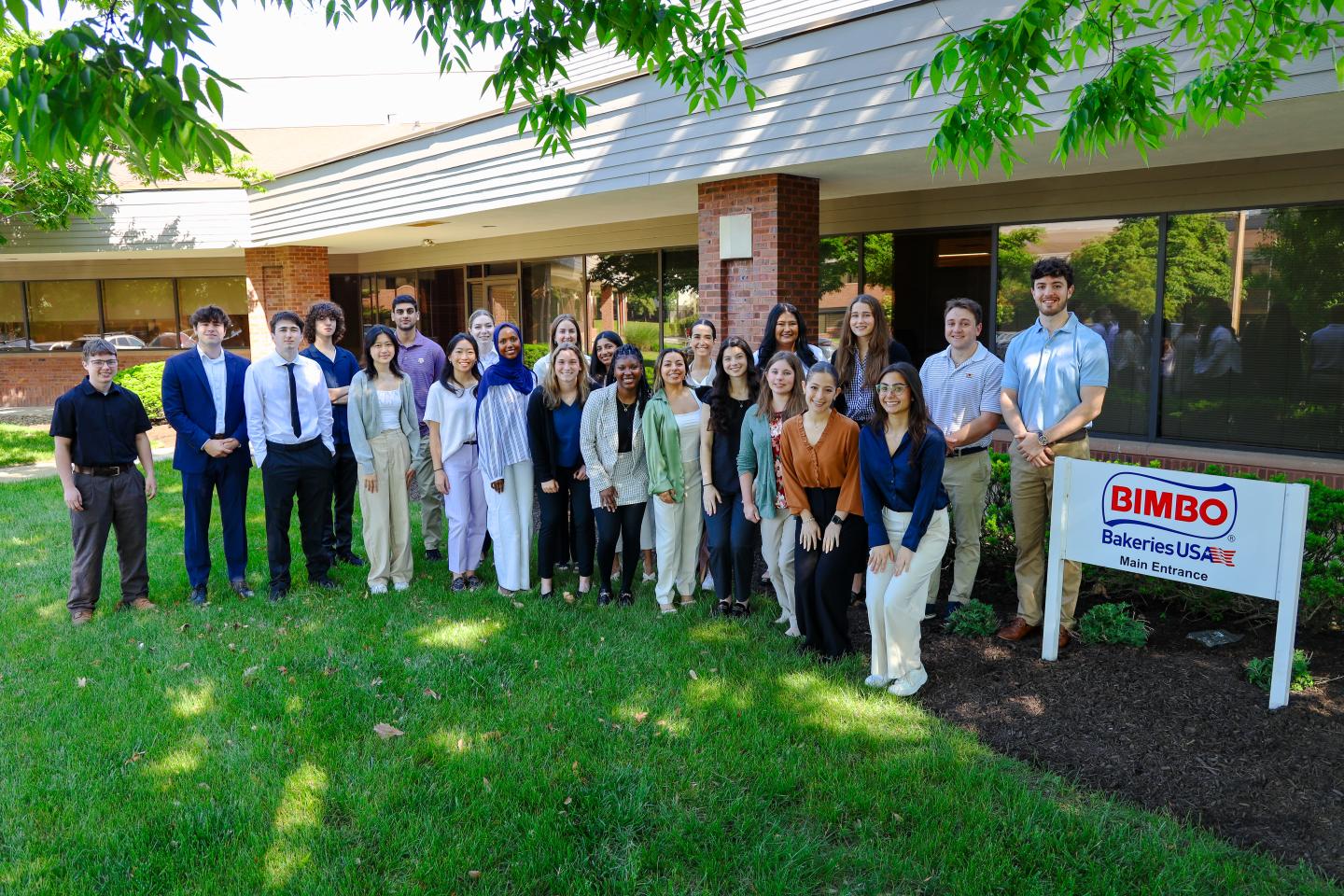 Group of interns in front of a Bimbo Bakeries USA sign